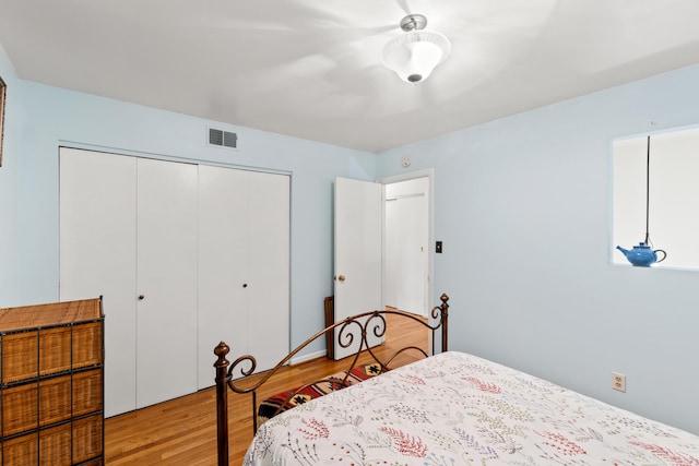 bedroom featuring light wood-type flooring, a closet, and visible vents