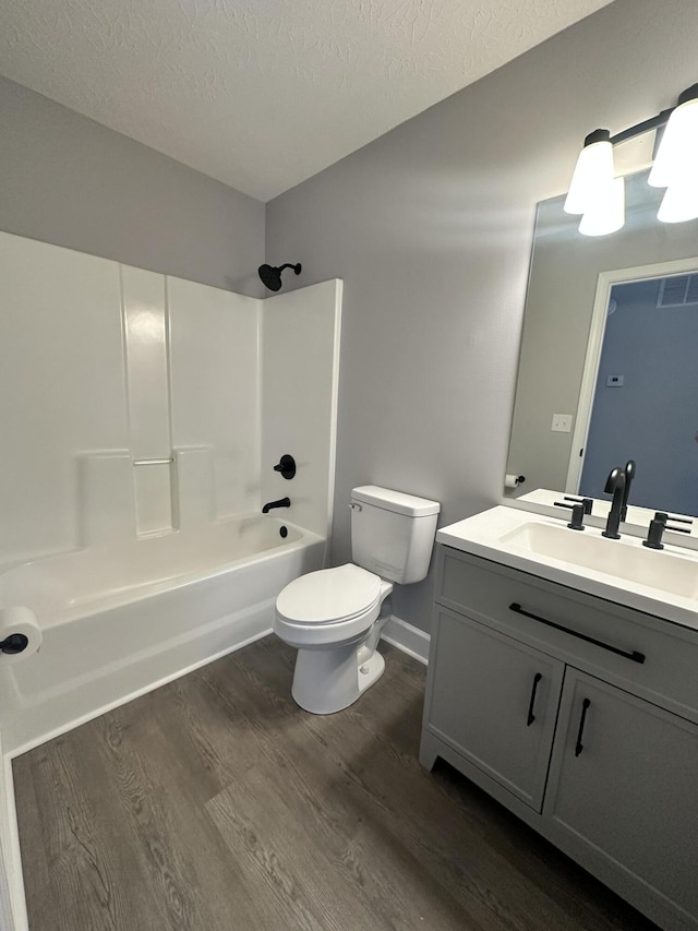 full bath with a textured ceiling, shower / tub combination, toilet, wood finished floors, and visible vents