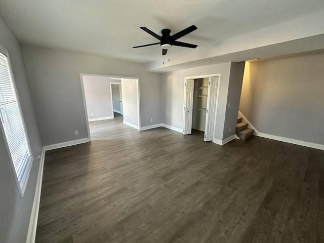 unfurnished bedroom with dark wood-style flooring, a ceiling fan, and baseboards