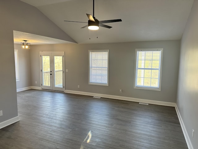 spare room featuring lofted ceiling, dark wood-style flooring, baseboards, and a healthy amount of sunlight