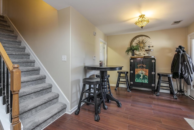 dining space featuring visible vents, dark wood finished floors, stairway, and baseboards