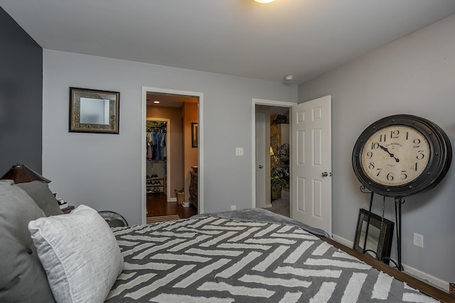 bedroom featuring baseboards, a walk in closet, and a closet