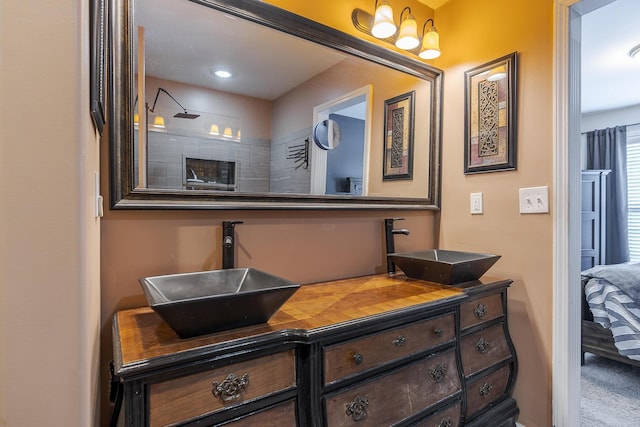 bathroom with a shower, a sink, and double vanity