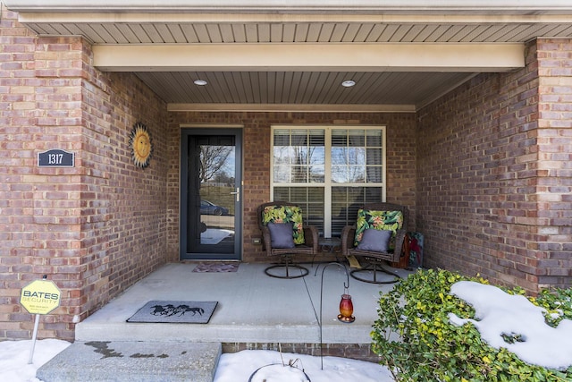 view of exterior entry featuring brick siding