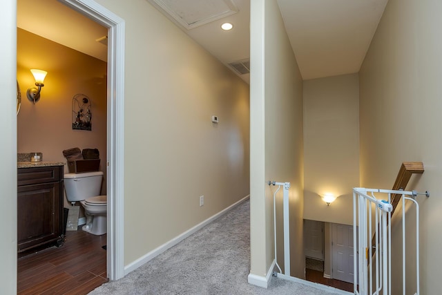 hall featuring recessed lighting, baseboards, visible vents, and an upstairs landing