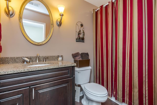 full bathroom featuring toilet, vanity, and visible vents