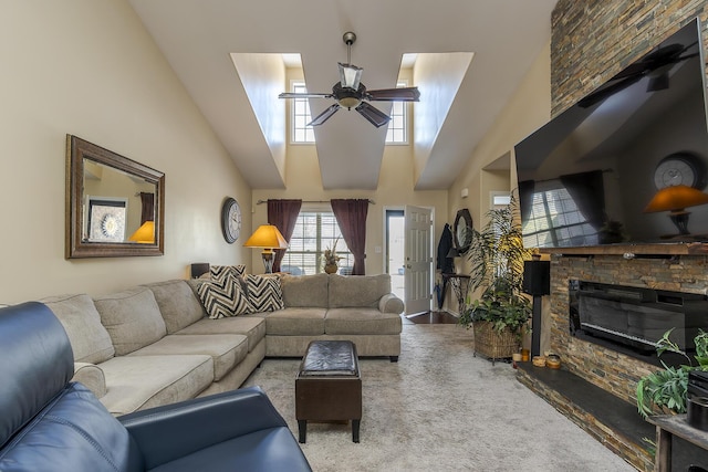 carpeted living room featuring ceiling fan, a high ceiling, and a fireplace