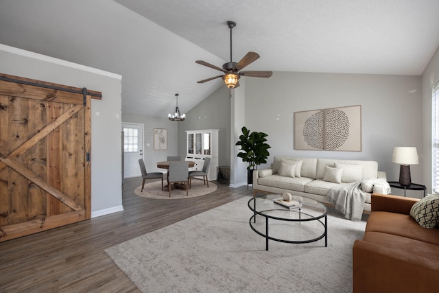 living room featuring high vaulted ceiling, ceiling fan with notable chandelier, wood finished floors, a barn door, and baseboards