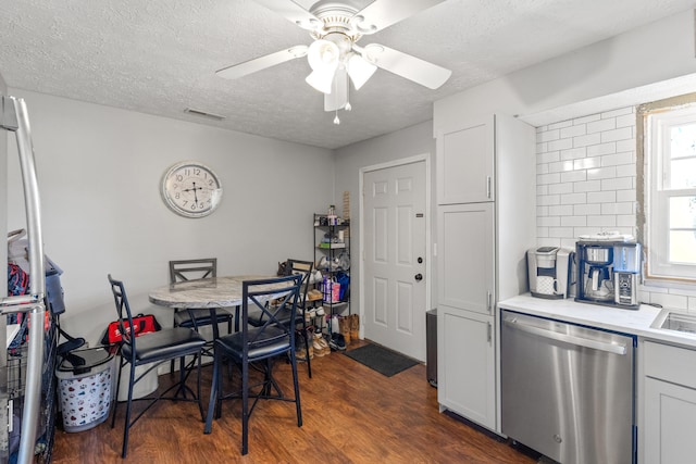 dining space featuring dark wood-type flooring, visible vents, ceiling fan, and a textured ceiling