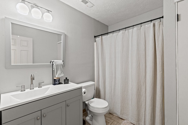 bathroom featuring visible vents, a shower with shower curtain, toilet, a textured ceiling, and vanity