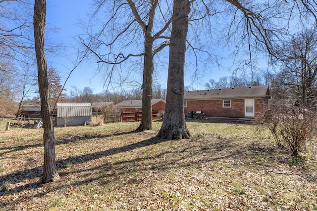 view of yard with a storage unit, an outdoor structure, and fence