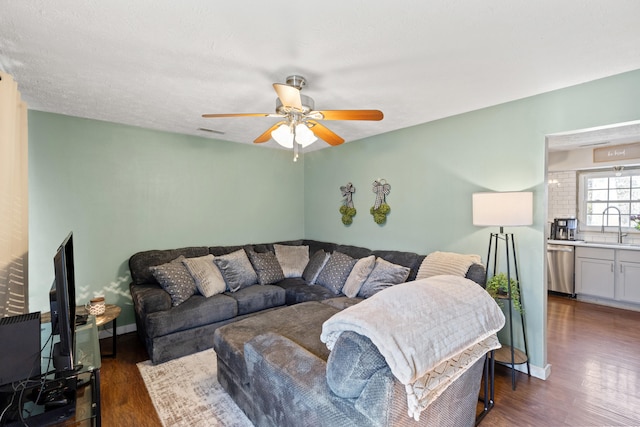 living room featuring baseboards, visible vents, ceiling fan, dark wood-style flooring, and a textured ceiling