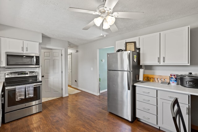 kitchen featuring stainless steel appliances, white cabinets, light countertops, tasteful backsplash, and dark wood finished floors