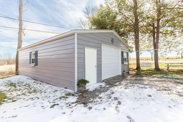 snow covered garage with a detached garage