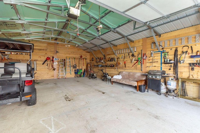 garage featuring a workshop area, metal wall, and a garage door opener