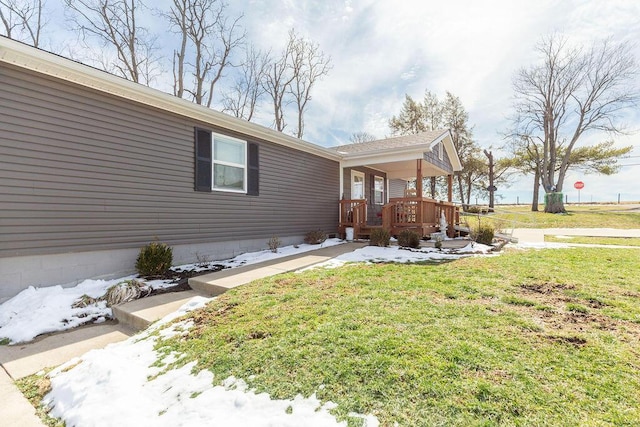 exterior space featuring covered porch and a yard