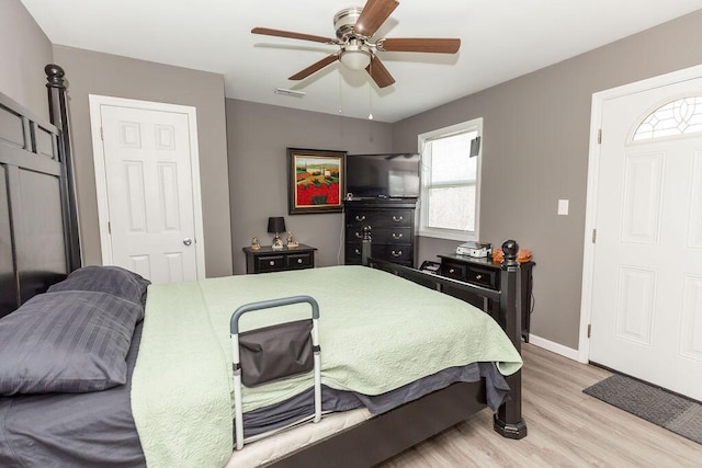 bedroom with baseboards, visible vents, ceiling fan, and light wood finished floors