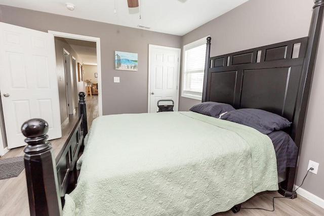 bedroom with baseboards, ceiling fan, visible vents, and light wood-style floors