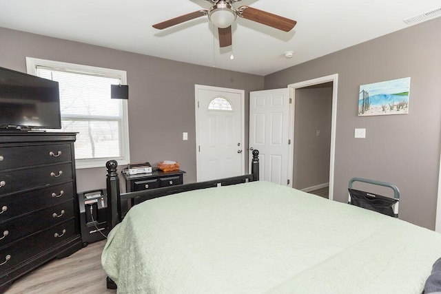 bedroom with light wood-style floors, visible vents, and ceiling fan