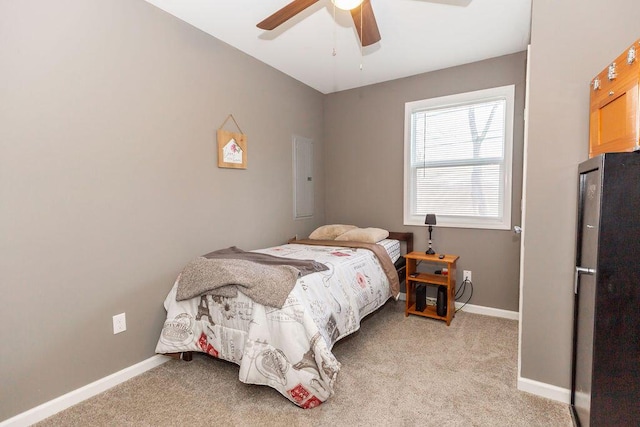 bedroom with a ceiling fan, freestanding refrigerator, light carpet, and baseboards