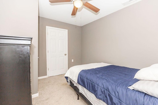 bedroom with a ceiling fan, visible vents, light carpet, and baseboards