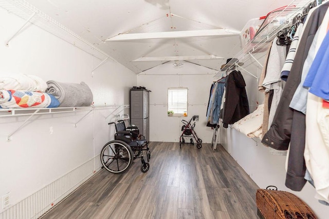 walk in closet with lofted ceiling with beams and wood finished floors