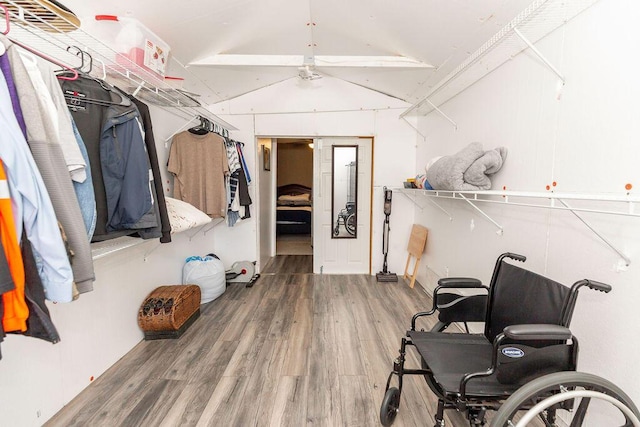 spacious closet with a ceiling fan, lofted ceiling, and wood finished floors