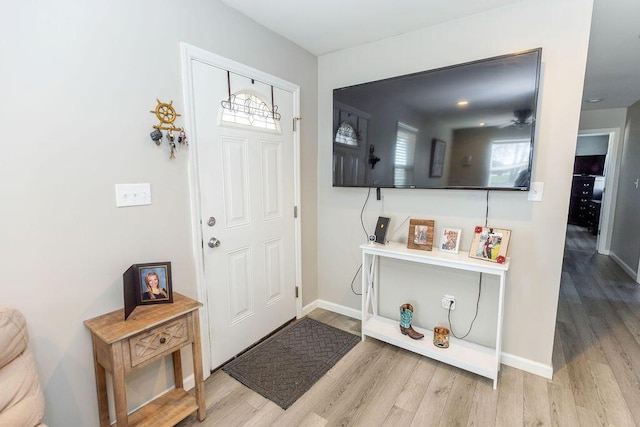 entrance foyer featuring a healthy amount of sunlight, light wood-style flooring, and baseboards