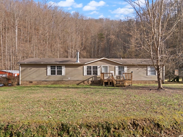 manufactured / mobile home featuring a wooded view, a front lawn, crawl space, and a wooden deck