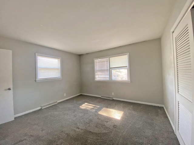 unfurnished bedroom with multiple windows, carpet flooring, visible vents, and baseboards