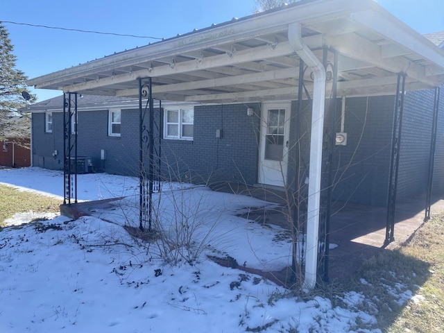 exterior space with a carport and brick siding