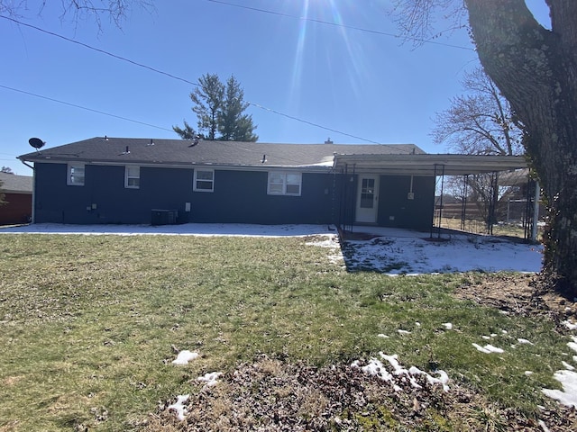 rear view of house with a carport, a lawn, and a patio