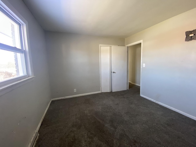 unfurnished bedroom with carpet floors and baseboards