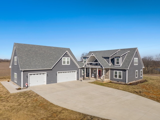 craftsman inspired home featuring covered porch, driveway, roof with shingles, and a front yard