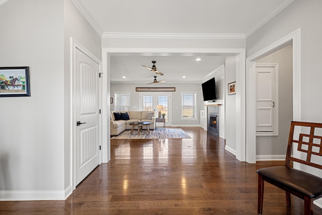 hallway featuring crown molding, baseboards, and dark wood-type flooring