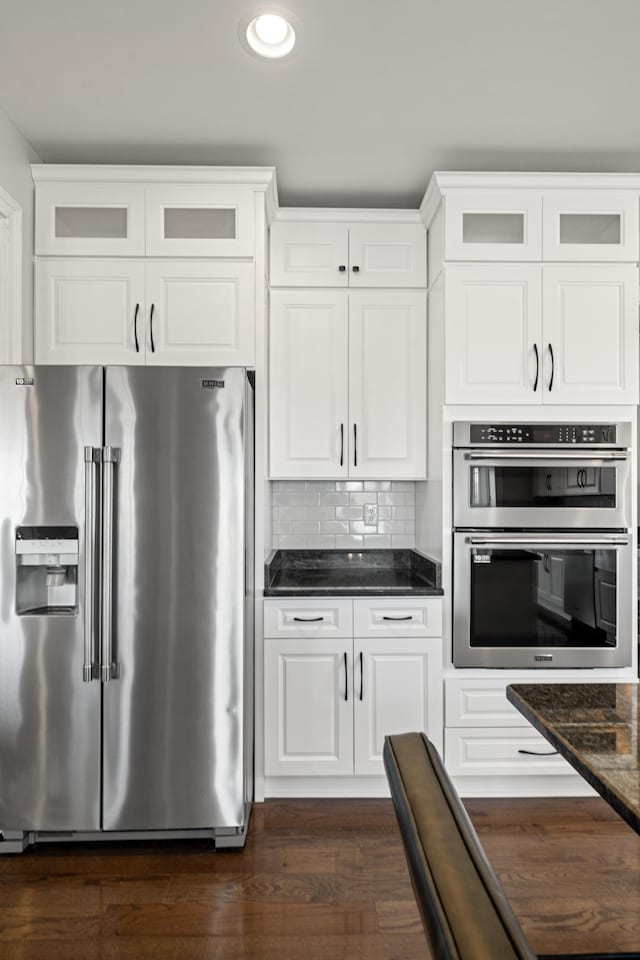 kitchen with stainless steel appliances, backsplash, glass insert cabinets, and white cabinetry