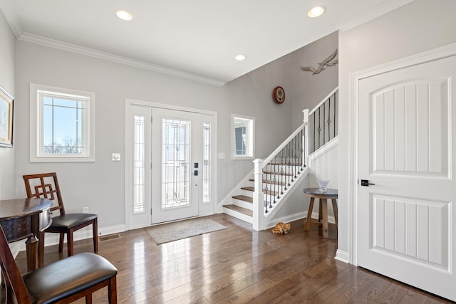 entrance foyer featuring dark wood-style floors, ornamental molding, baseboards, and stairs