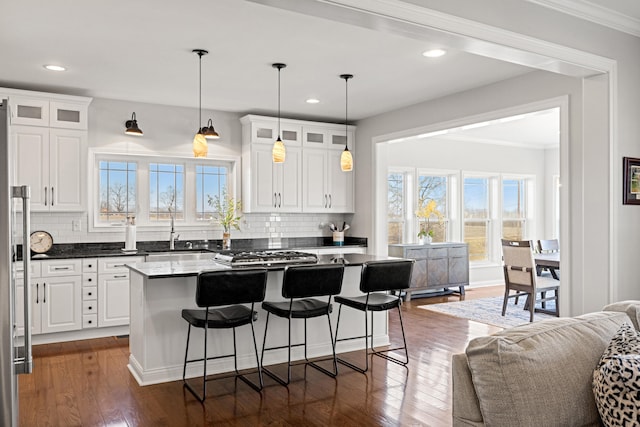 kitchen with dark wood-type flooring, a breakfast bar, and white cabinets