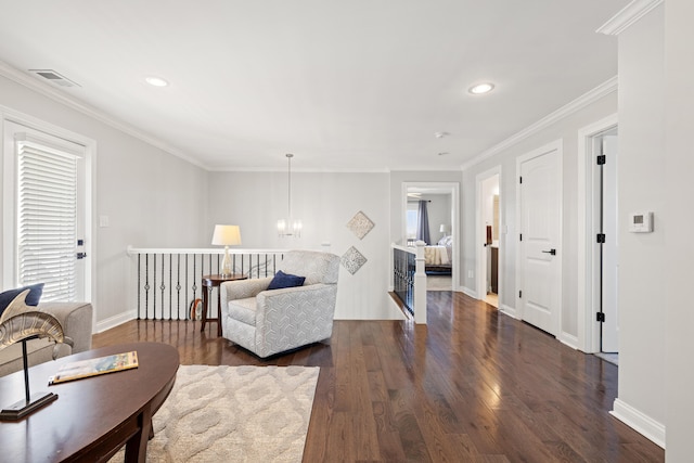 living area with a chandelier, dark wood-type flooring, visible vents, baseboards, and crown molding