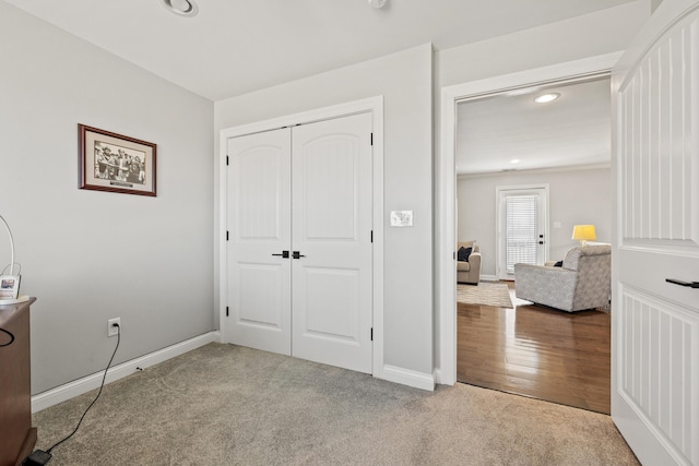 carpeted bedroom featuring a closet, recessed lighting, wood finished floors, and baseboards