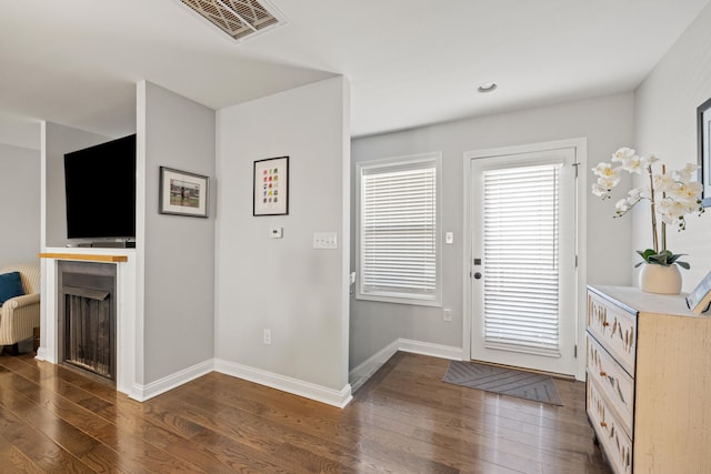 entryway featuring hardwood / wood-style flooring, visible vents, and baseboards