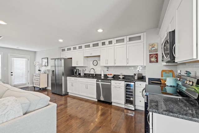 kitchen featuring wine cooler, stainless steel appliances, a sink, white cabinetry, and dark wood finished floors