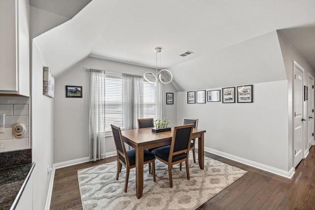 dining room with lofted ceiling, visible vents, dark wood finished floors, and baseboards