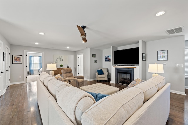 living area featuring dark wood-style floors, recessed lighting, visible vents, and baseboards