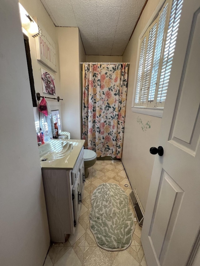 bathroom with visible vents, a shower with shower curtain, toilet, tile patterned floors, and vanity