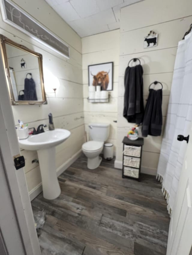 bathroom with toilet and wood finished floors