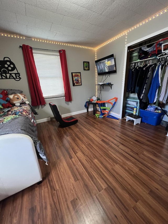 bedroom featuring a closet, wood finished floors, and baseboards