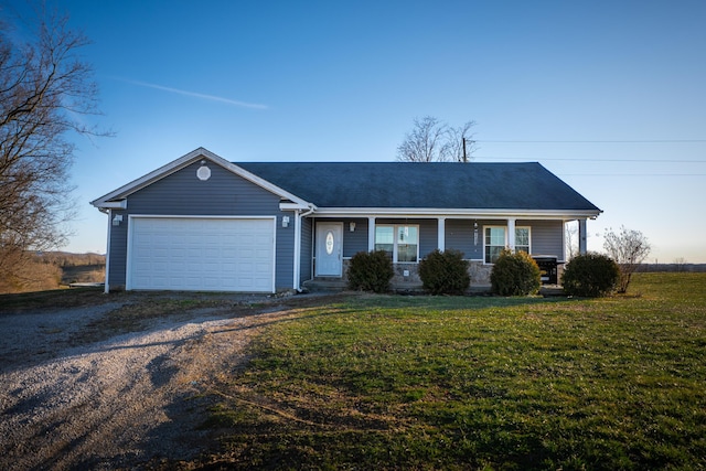 ranch-style home with a garage, a front yard, and driveway