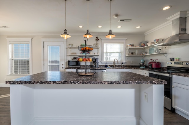 kitchen with stainless steel appliances, a sink, a kitchen island, wall chimney range hood, and open shelves