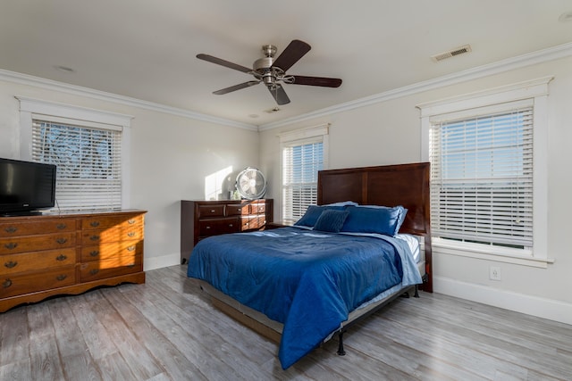 bedroom with visible vents, ornamental molding, and wood finished floors